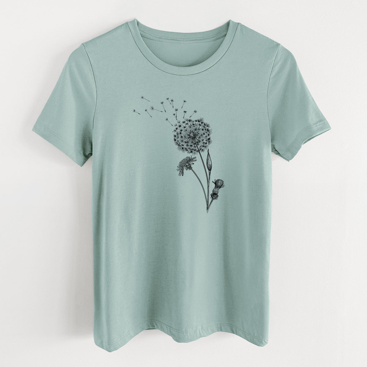 Dusty blue women's relaxed fit cotton t-shirt laid flat, printed with a black ink line drawing of a dandelion seed head with seeds blowing away.