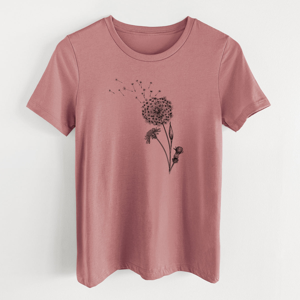 Mauve pink women's relaxed fit cotton t-shirt laid flat, printed with a black ink line drawing of a dandelion seed head with seeds blowing away.