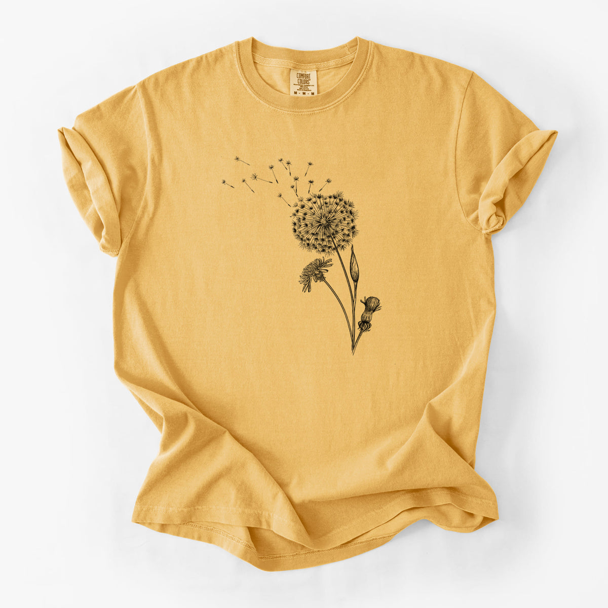 Golden wheat yellow Comfort Colors t-shirt laid flat, printed with a black ink line drawing of a dandelion seed head with seeds blowing away.