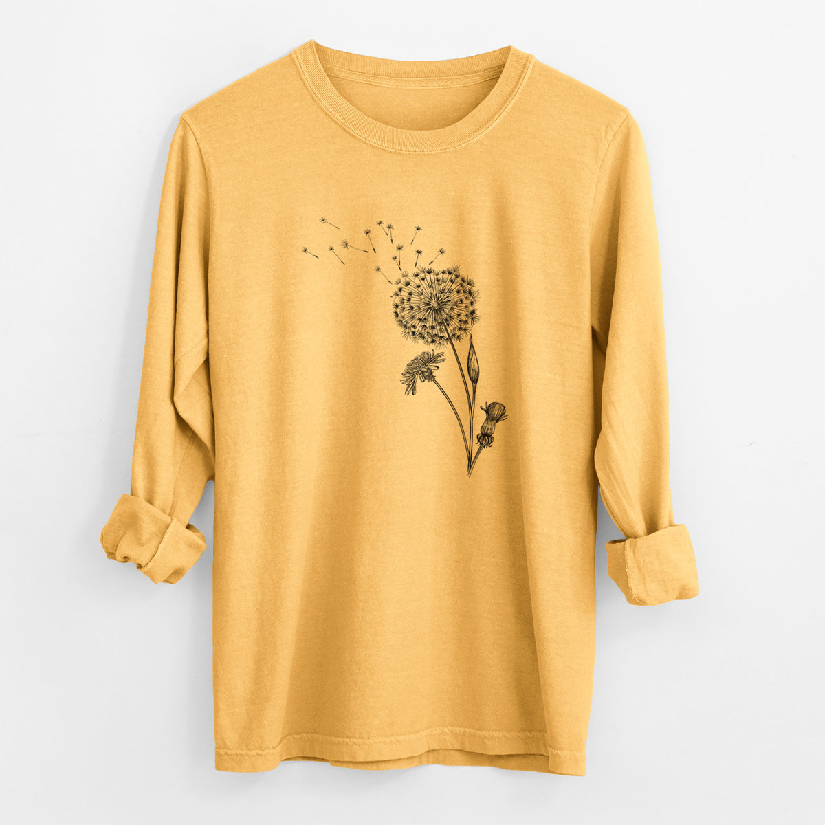 Golden wheat yellow Comfort Colors long sleeve shirt laid flat with the cuffs rolled, printed with a black ink line drawing of a dandelion seed head with seeds blowing away.