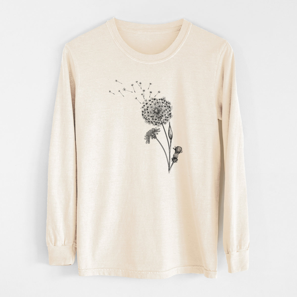 Ivory Comfort Colors long sleeve shirt laid flat, printed with a black ink line drawing of a dandelion seed head with seeds blowing away.
