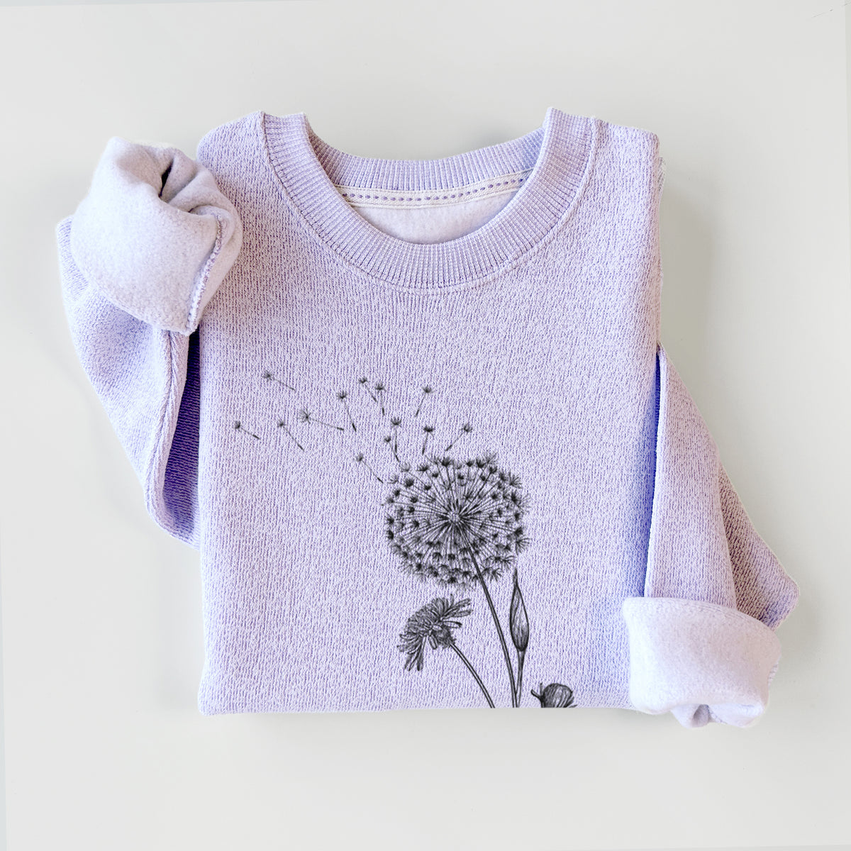 Ice purple knit sweatshirt printed with a black ink line drawing of a dandelion seed head with seeds blowing away, styled flat.