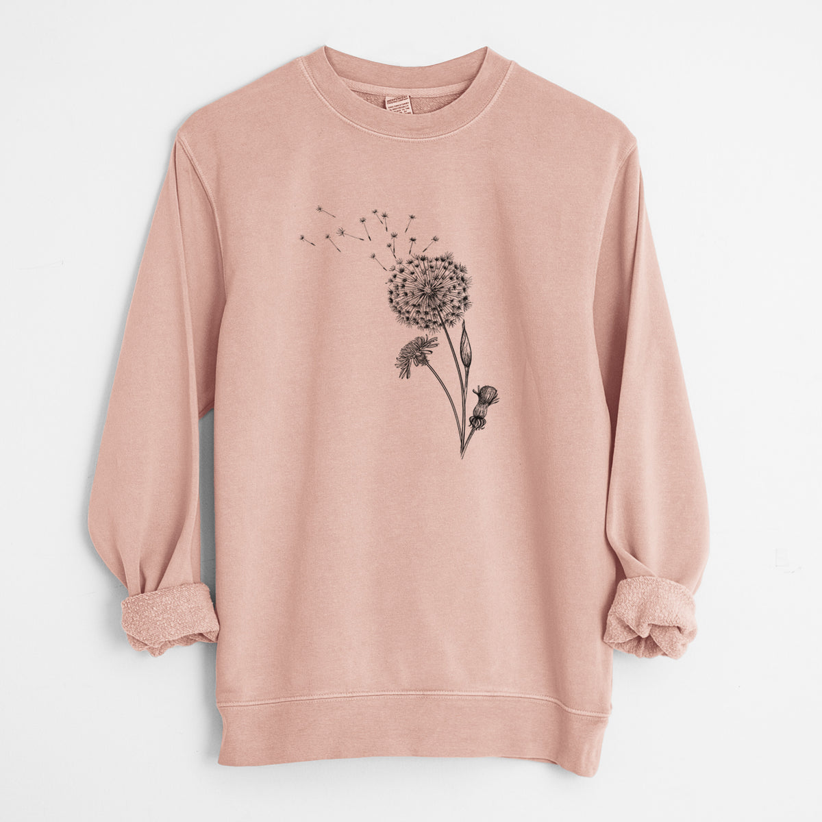 Dusty pink pigment dyed crewneck sweatshirt laid flat with the sleeves rolled, printed with a black ink line drawing of a dandelion seed head with seeds blowing away.