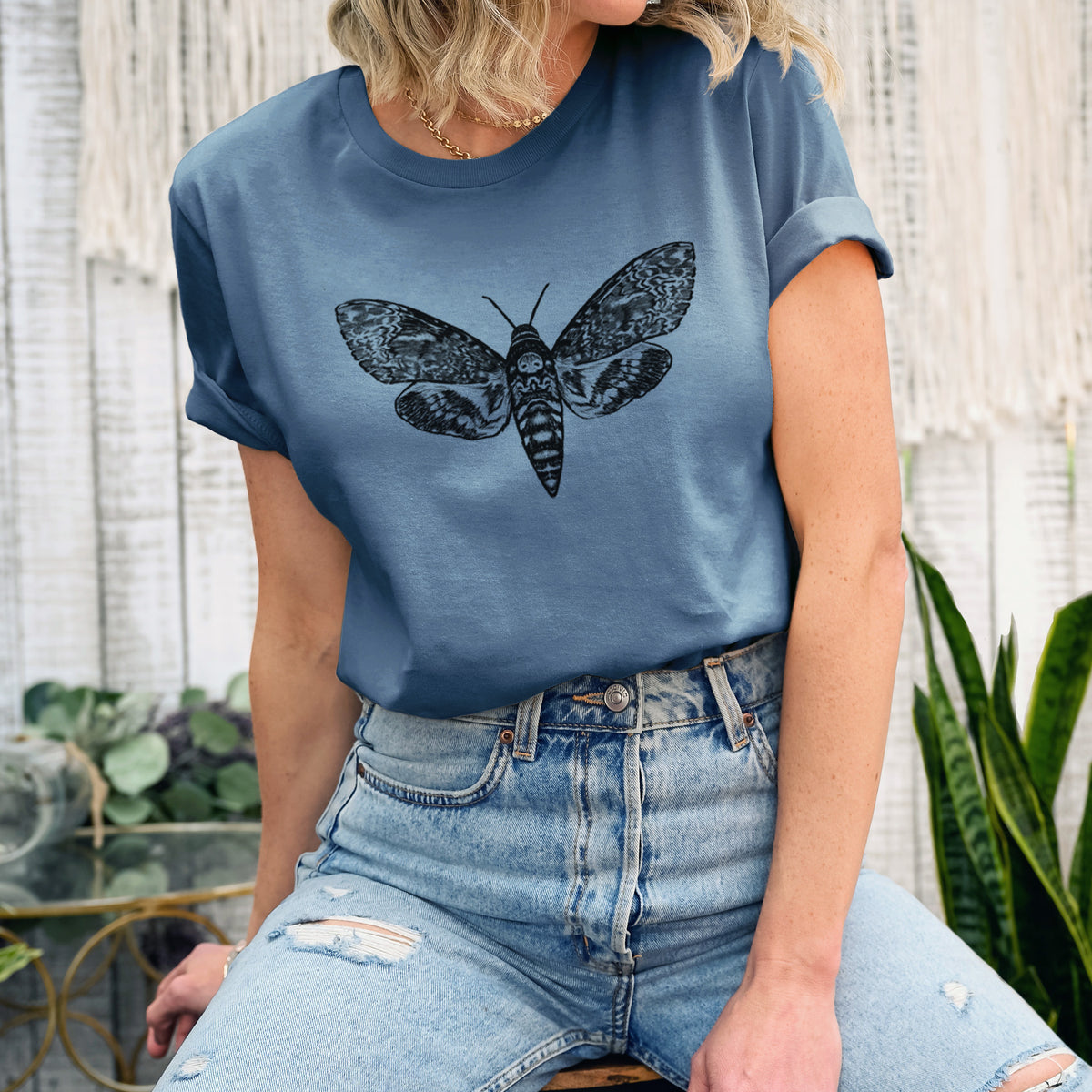 Woman wearing a steel blue lightweight cotton t-shirt printed with a detailed black ink illustration of a death's-head hawkmoth with its wings spread.