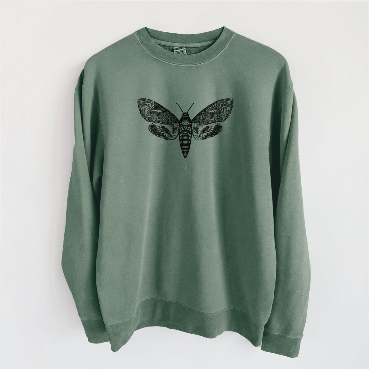 Alpine green pigment dyed crewneck sweatshirt laid flat, printed with a detailed black ink illustration of a death's-head hawkmoth with its wings spread.