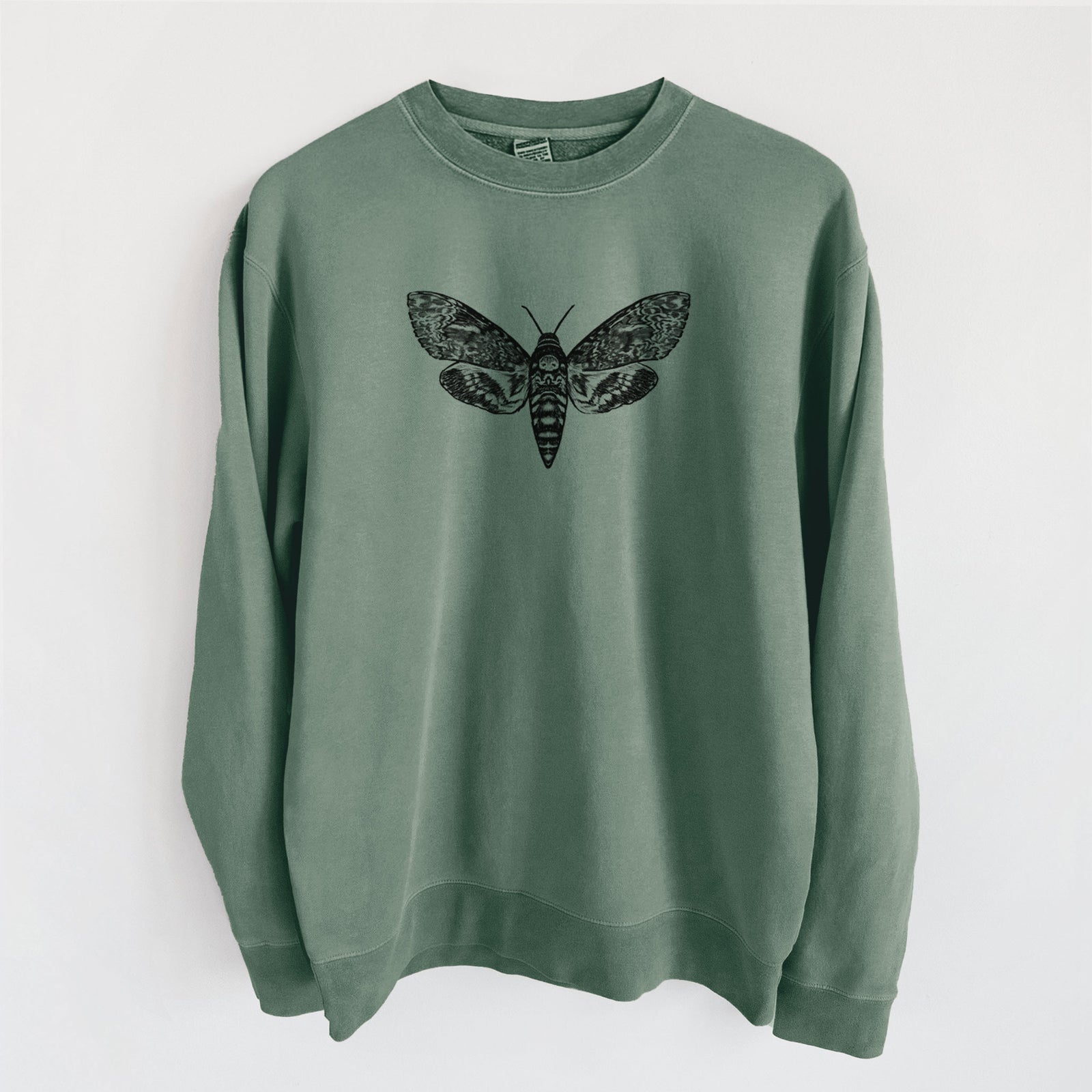 Alpine green pigment dyed crewneck sweatshirt laid flat, printed with a detailed black ink illustration of a death's-head hawkmoth with its wings spread.