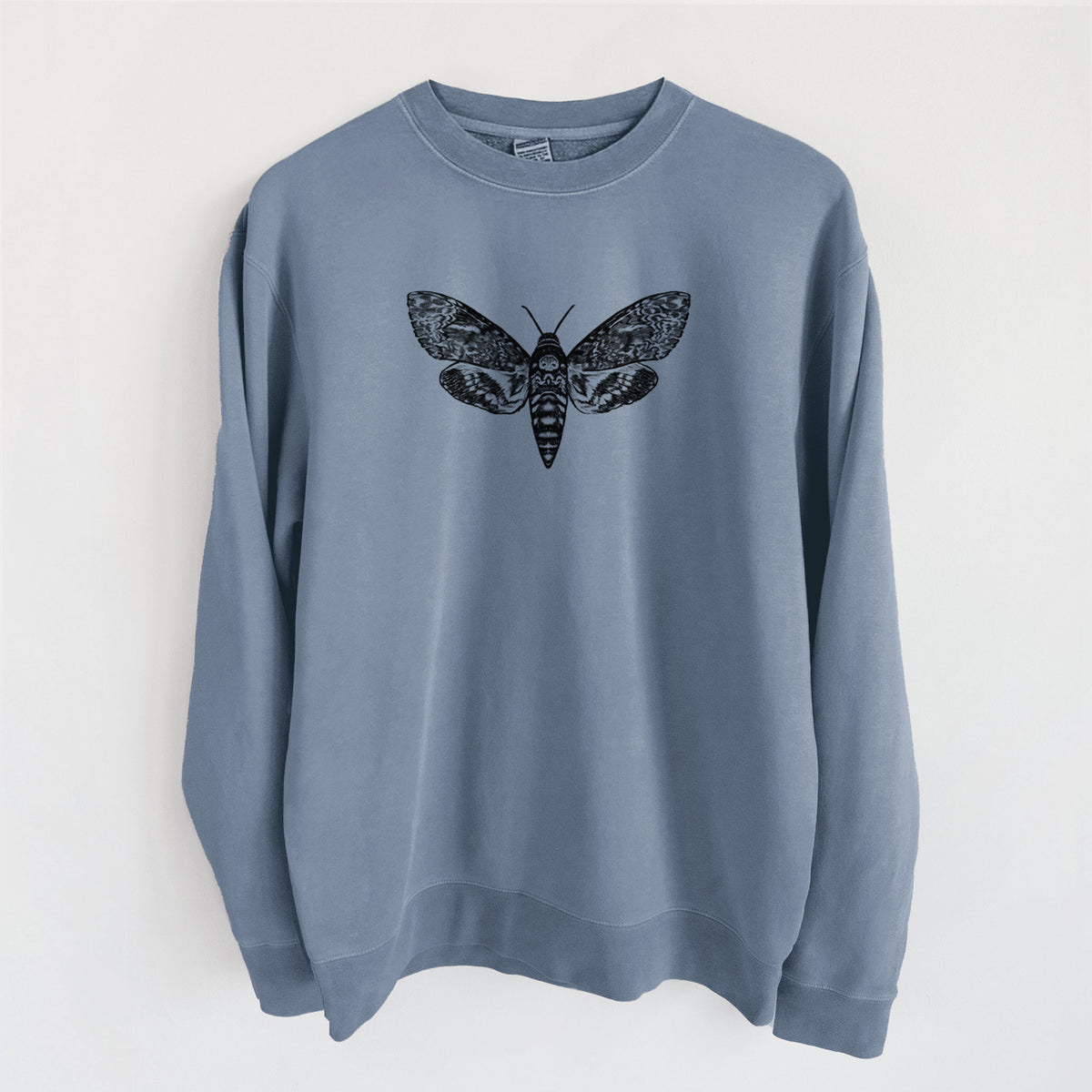 Slate blue pigment dyed crewneck sweatshirt laid flat, printed with a detailed black ink illustration of a death's-head hawkmoth with its wings spread.
