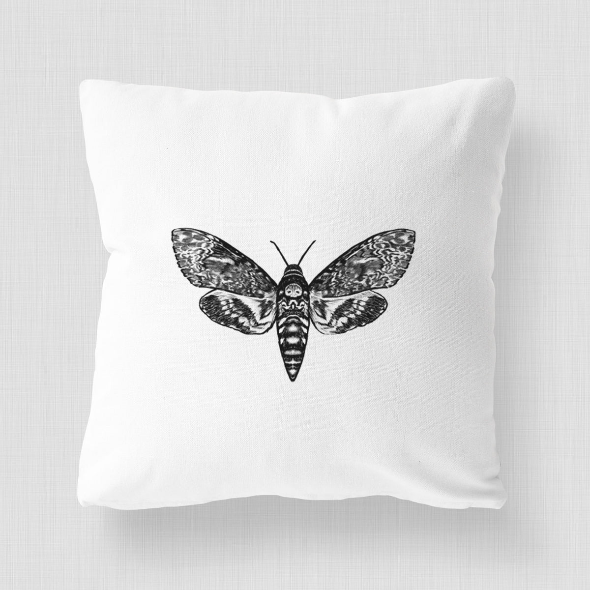 White pillow cover printed with a detailed black ink illustration of a death's-head hawkmoth with its wings spread.