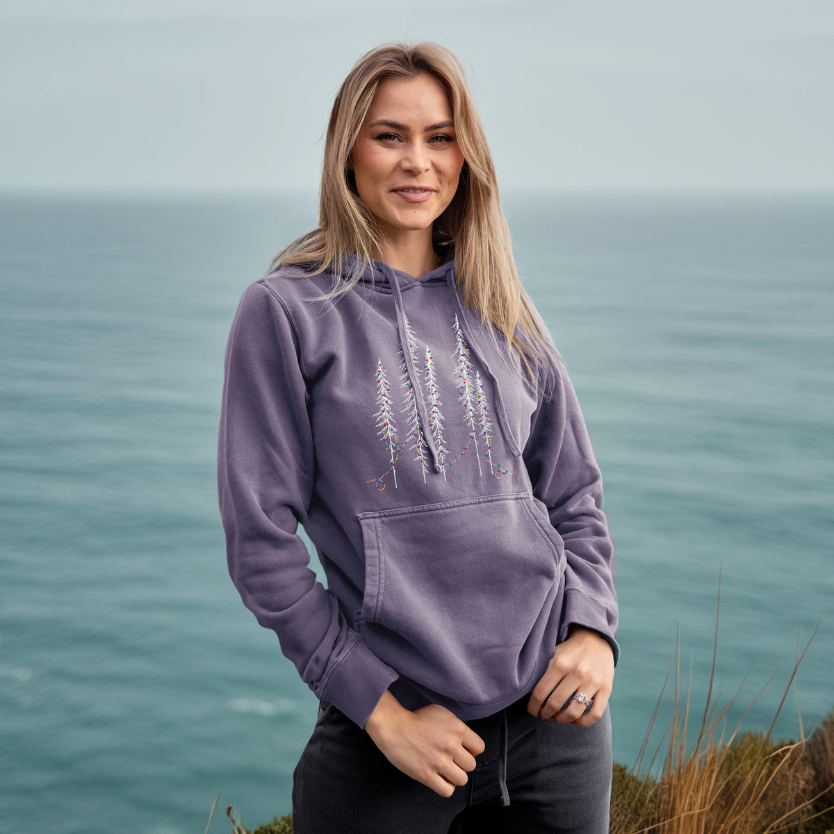 Christmas Deck the Redwoods - Unisex Pigment Dyed Hoodie in Plum, worn by model