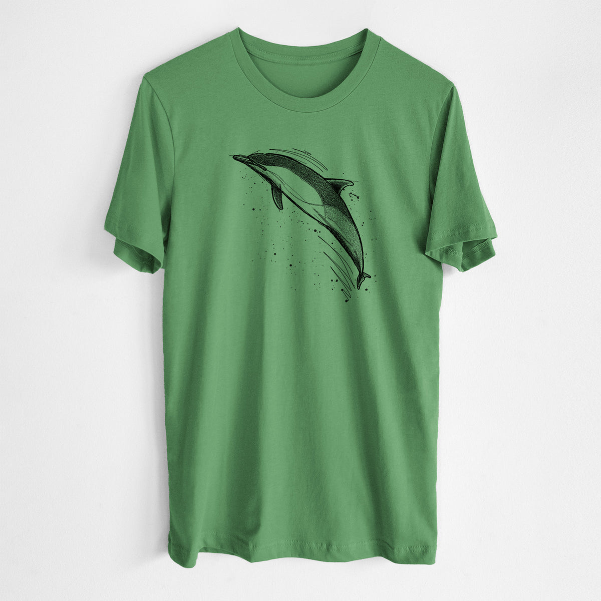 Leaf green lightweight cotton t-shirt laid flat, printed with a black ink illustration of a common dolphin leaping, with ink splatters.