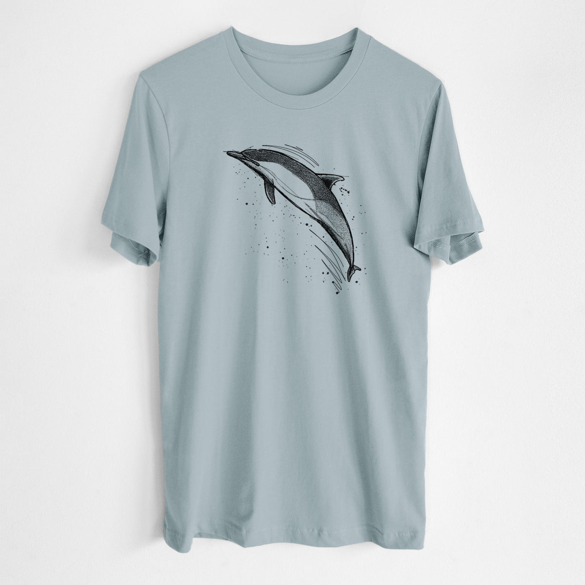 Vintage denim lightweight cotton t-shirt laid flat, printed with a black ink illustration of a common dolphin leaping, with ink splatters.
