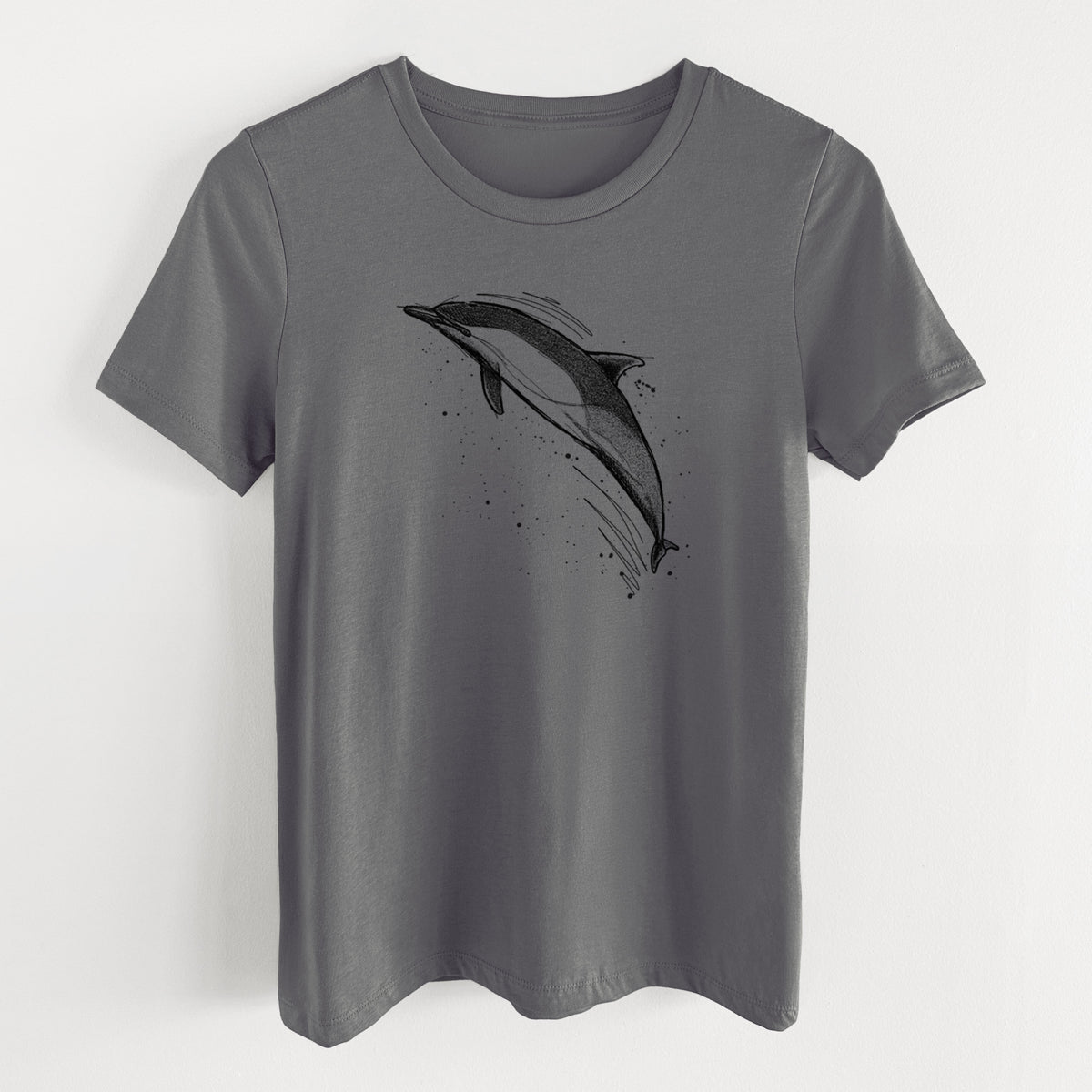Asphalt women's relaxed fit cotton t-shirt laid flat, printed with a black ink illustration of a common dolphin leaping, with ink splatters.