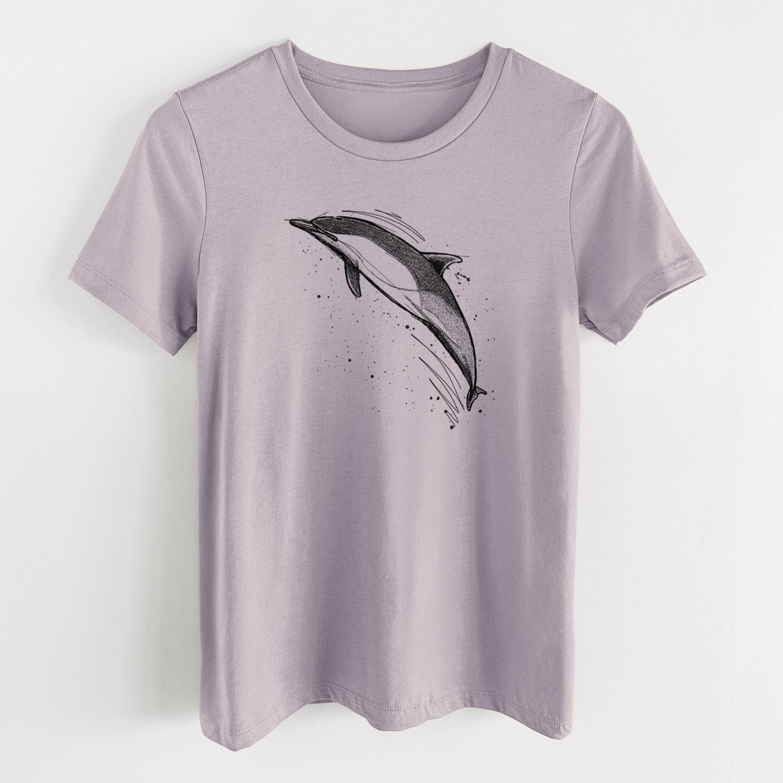 Light violet women's relaxed fit cotton t-shirt laid flat, printed with a black ink illustration of a common dolphin leaping, with ink splatters.