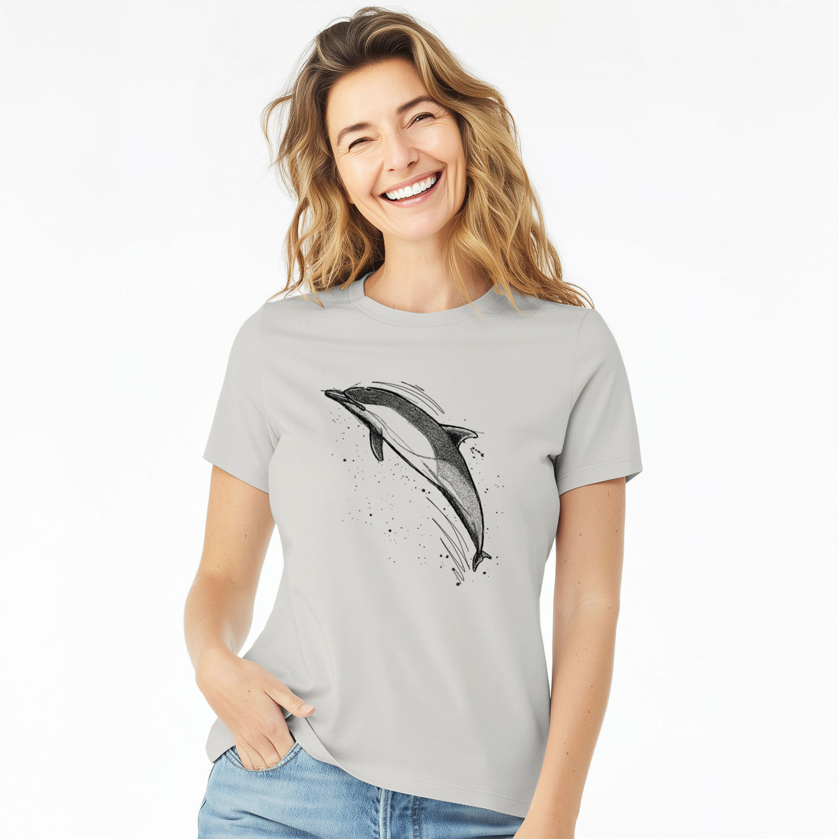 Woman wearing a lunar grey women's relaxed fit cotton t-shirt printed with a black ink illustration of a common dolphin leaping, with ink splatters.