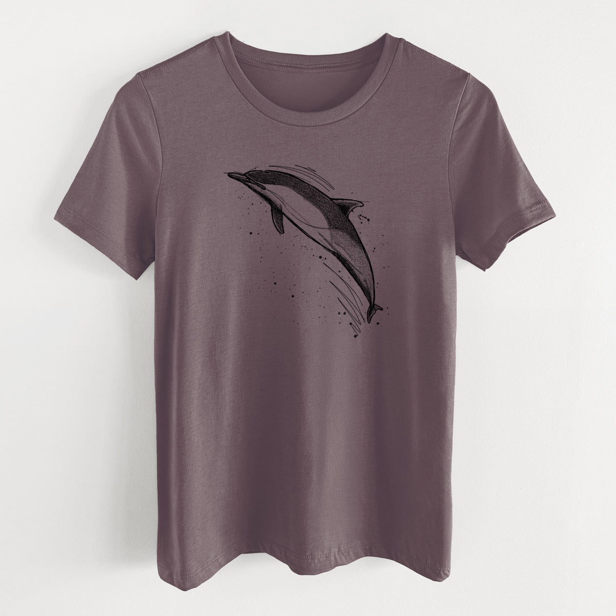 Purple storm women's relaxed fit cotton t-shirt laid flat, printed with a black ink illustration of a common dolphin leaping, with ink splatters.