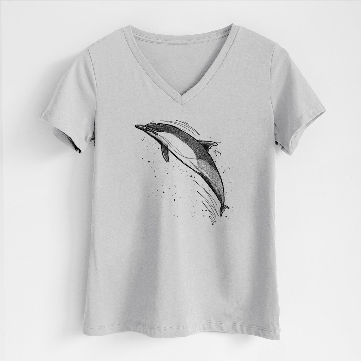 Lunar grey women's relaxed fit cotton V-neck t-shirt laid flat, printed with a black ink illustration of a common dolphin leaping, with ink splatters.