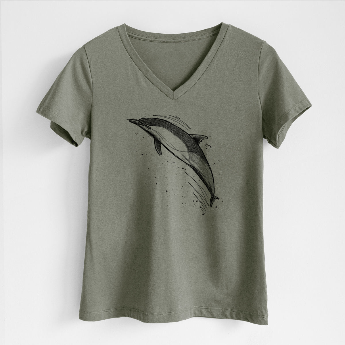 Military green women's relaxed fit cotton V-neck t-shirt laid flat, printed with a black ink illustration of a common dolphin leaping, with ink splatters.