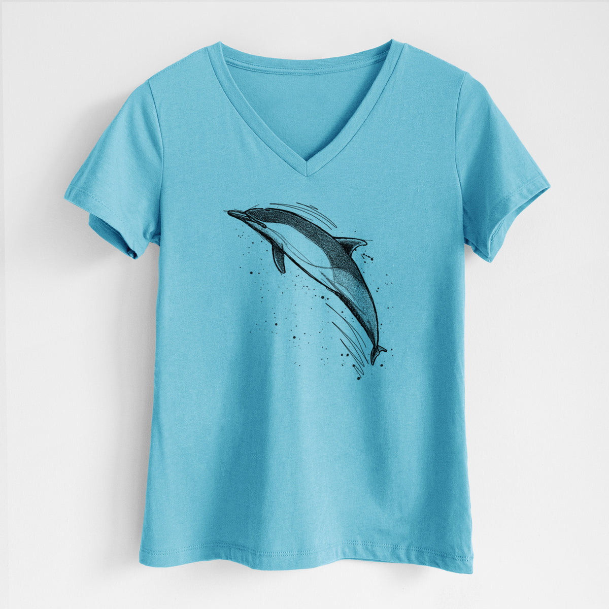 Turquoise women's relaxed fit cotton V-neck t-shirt laid flat, printed with a black ink illustration of a common dolphin leaping, with ink splatters.