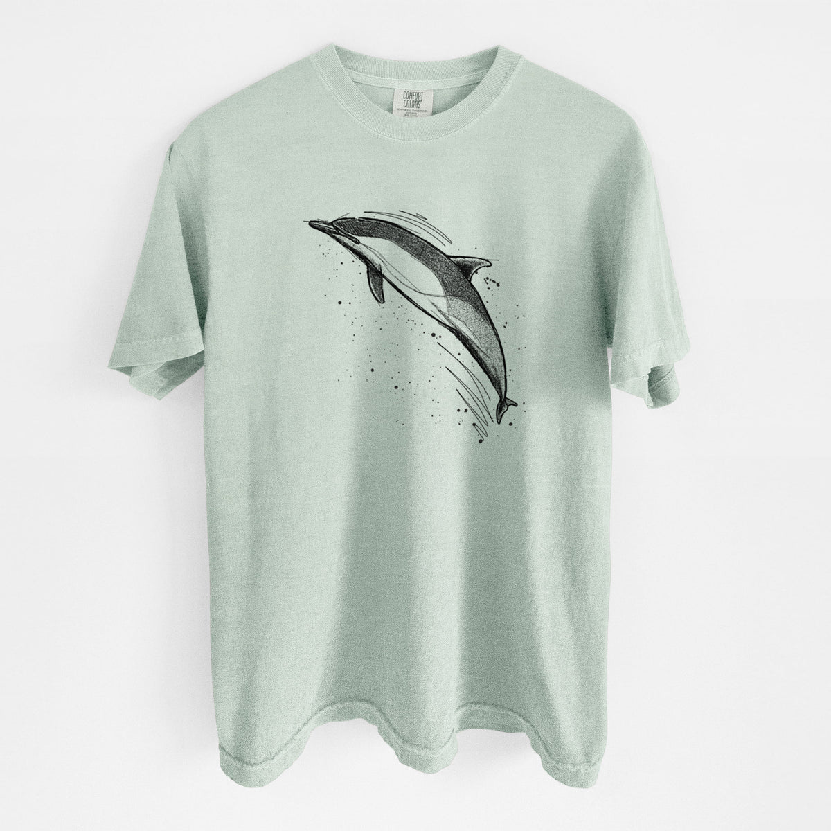 Bay green Comfort Colors t-shirt laid flat, printed with a black ink illustration of a common dolphin leaping, with ink splatters.