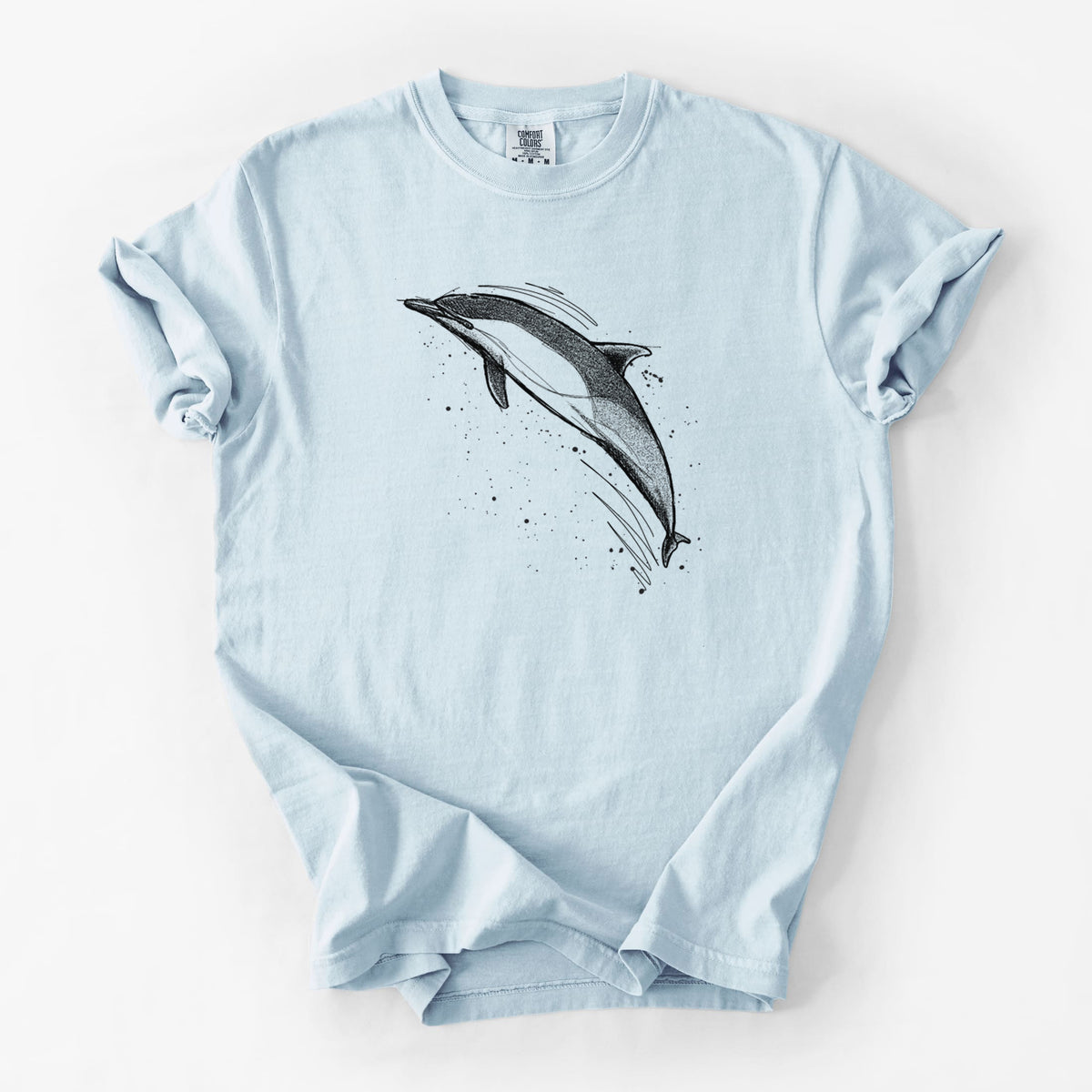 Chambray blue Comfort Colors t-shirt laid flat, printed with a black ink illustration of a common dolphin leaping, with ink splatters.