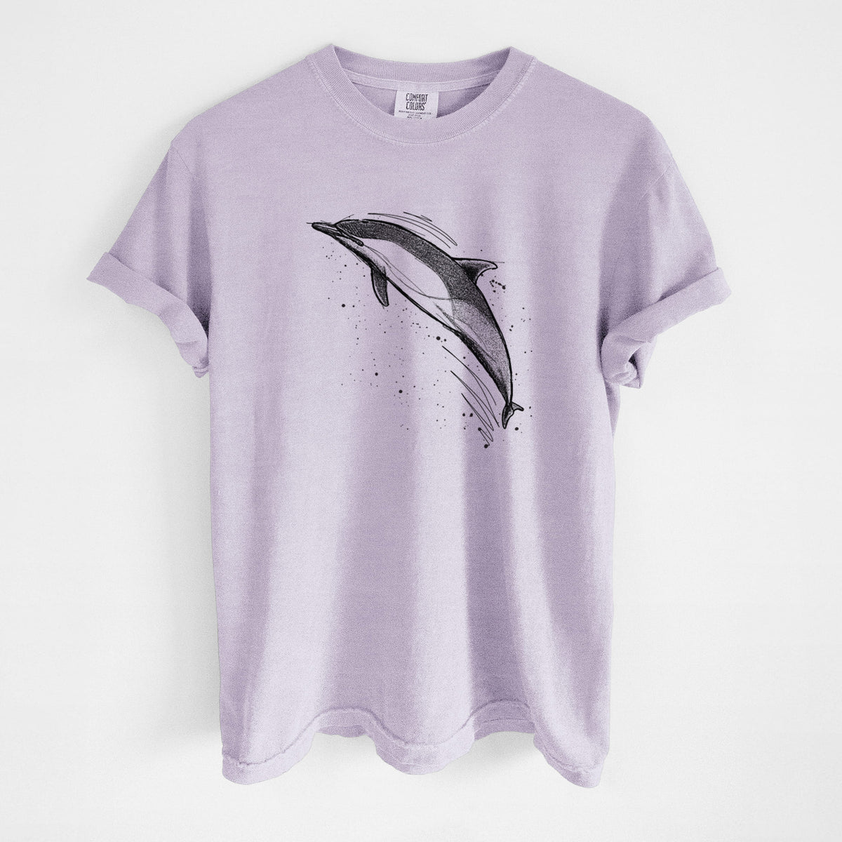 Orchid purple Comfort Colors t-shirt laid flat, printed with a black ink illustration of a common dolphin leaping, with ink splatters.