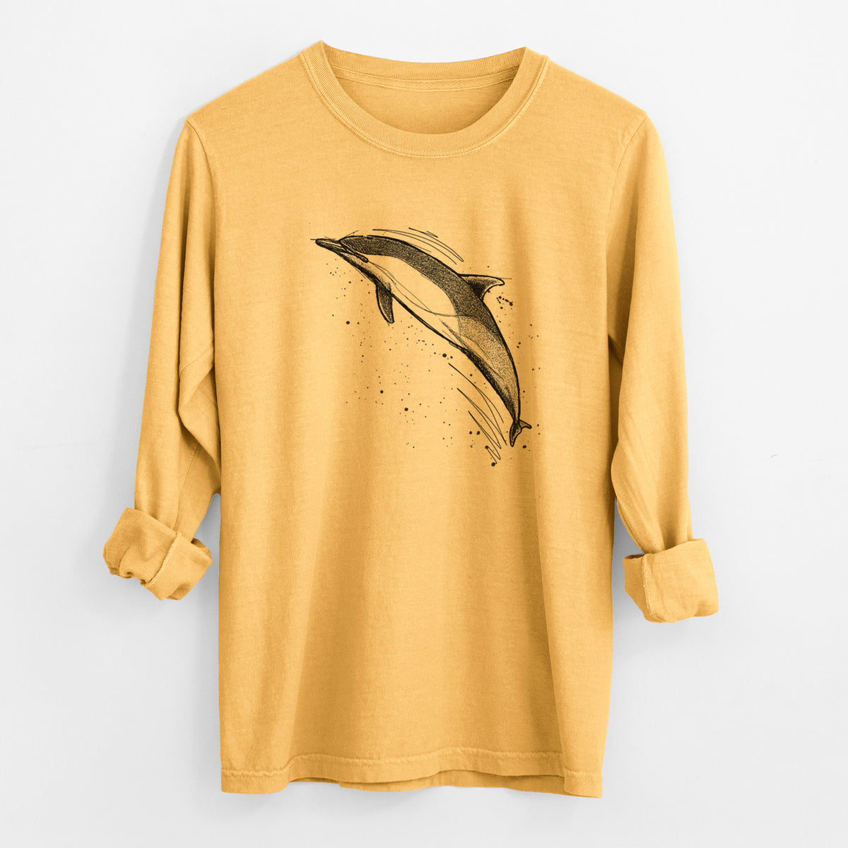 Golden wheat yellow Comfort Colors long sleeve shirt laid flat with the cuffs rolled, printed with a black ink illustration of a common dolphin leaping, with ink splatters.