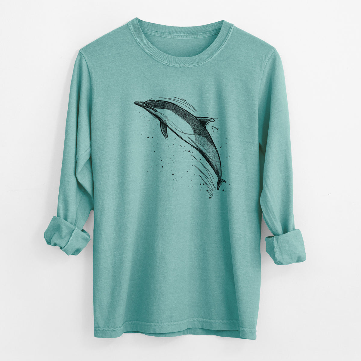 Reef green Comfort Colors long sleeve shirt laid flat with the cuffs rolled, printed with a black ink illustration of a common dolphin leaping, with ink splatters.