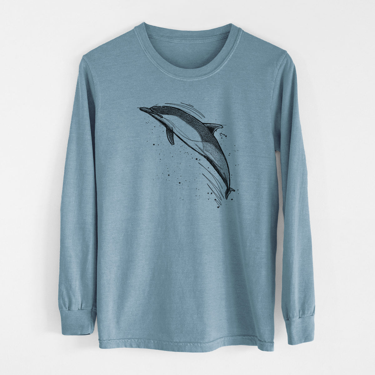 Steel blue Comfort Colors long sleeve shirt laid flat, printed with a black ink illustration of a common dolphin leaping, with ink splatters.