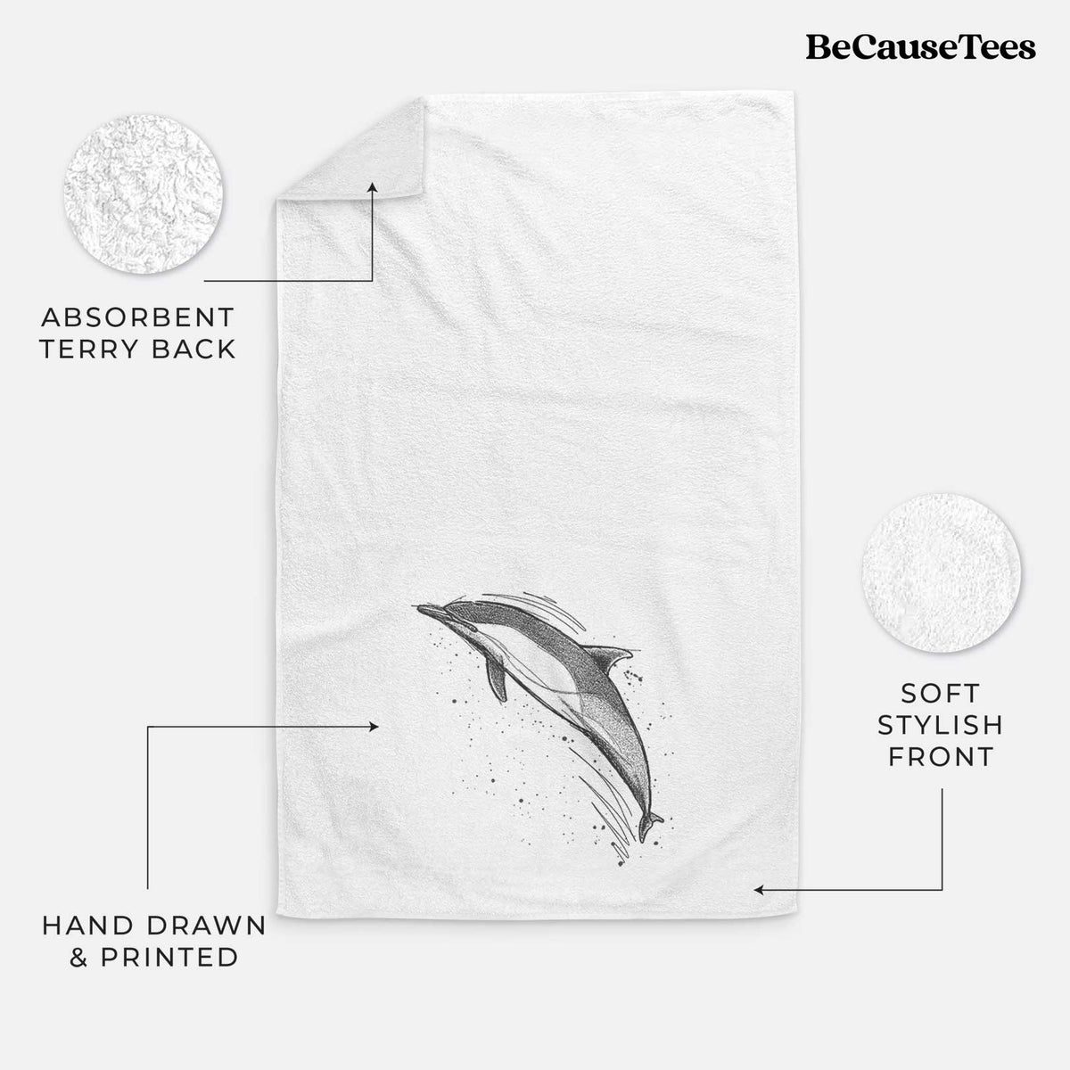White hand towel printed with a black ink illustration of a common dolphin leaping, with ink splatters.