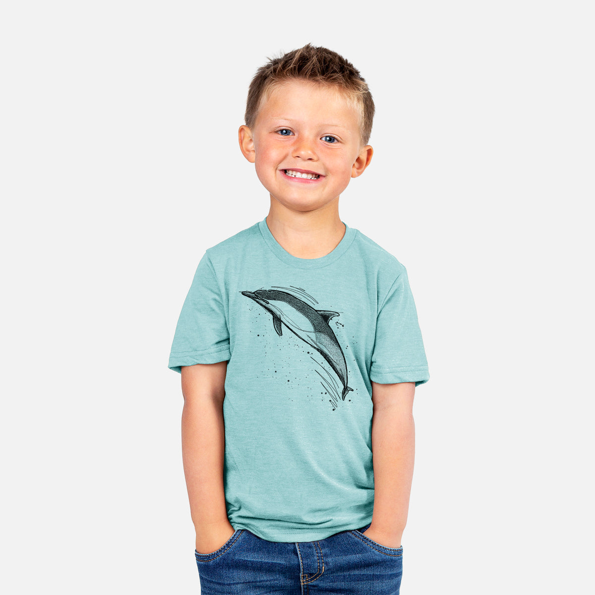 Smiling boy wearing a youth t-shirt printed with a black ink illustration of a common dolphin leaping, with ink splatters.