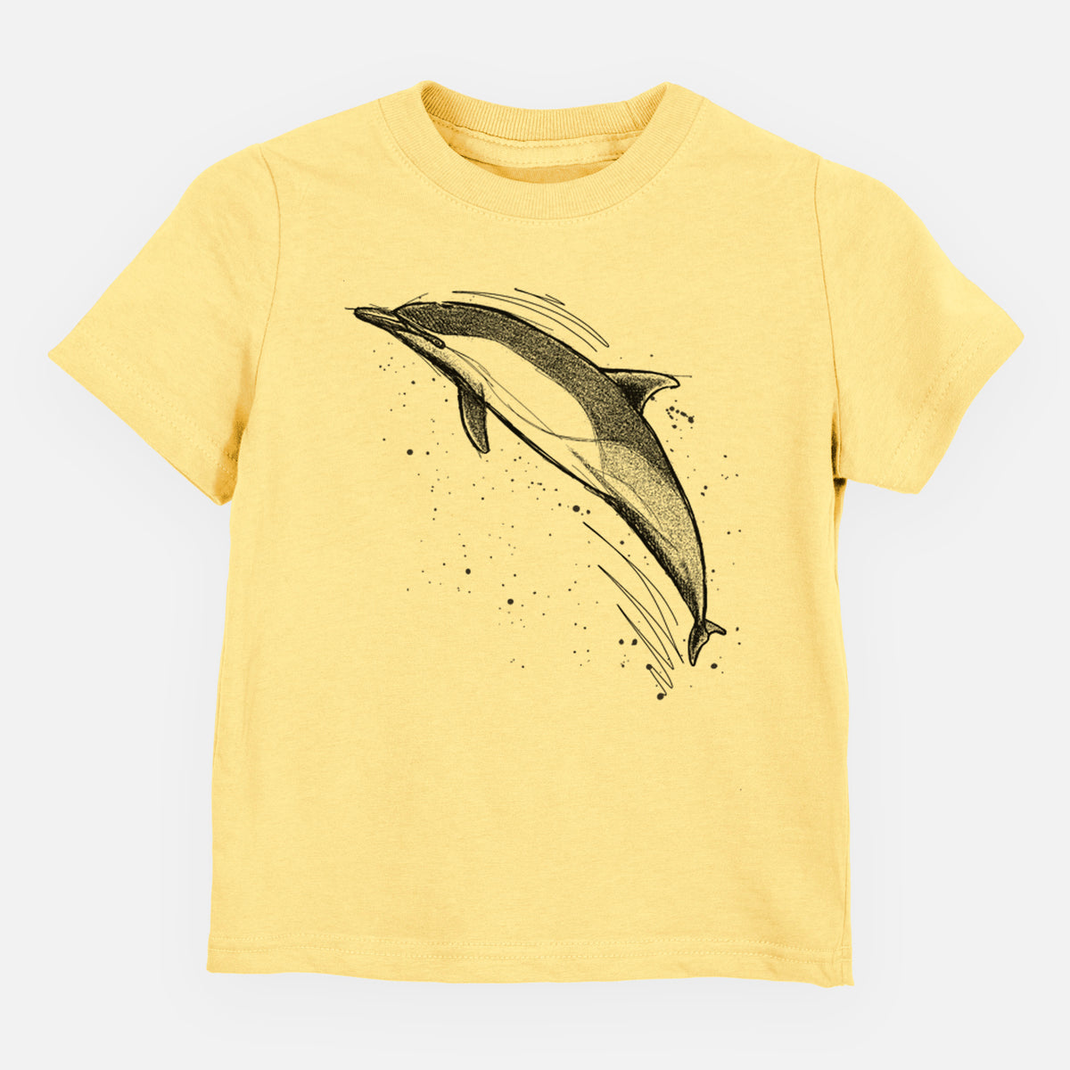 Butter yellow toddler t-shirt laid flat, printed with a black ink illustration of a common dolphin leaping, with ink splatters.