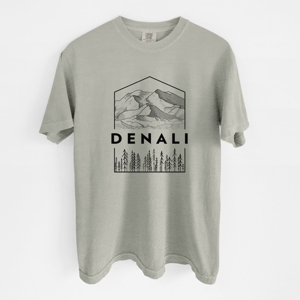 Sandstone beige Comfort Colors t-shirt laid flat, printed with a black line art badge of the Denali mountain range above pine trees, with the word Denali.