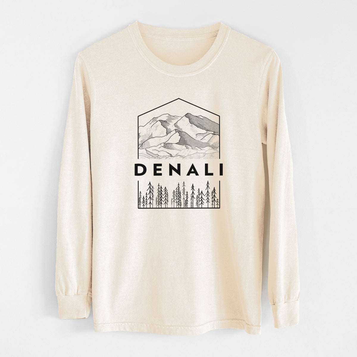 Ivory Comfort Colors long sleeve shirt laid flat, printed with a black line art badge of the Denali mountain range above pine trees, with the word Denali.