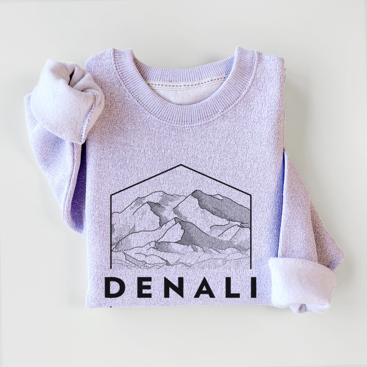 Ice purple knit sweatshirt printed with a black line art badge of the Denali mountain range above pine trees, with the word Denali, styled flat.