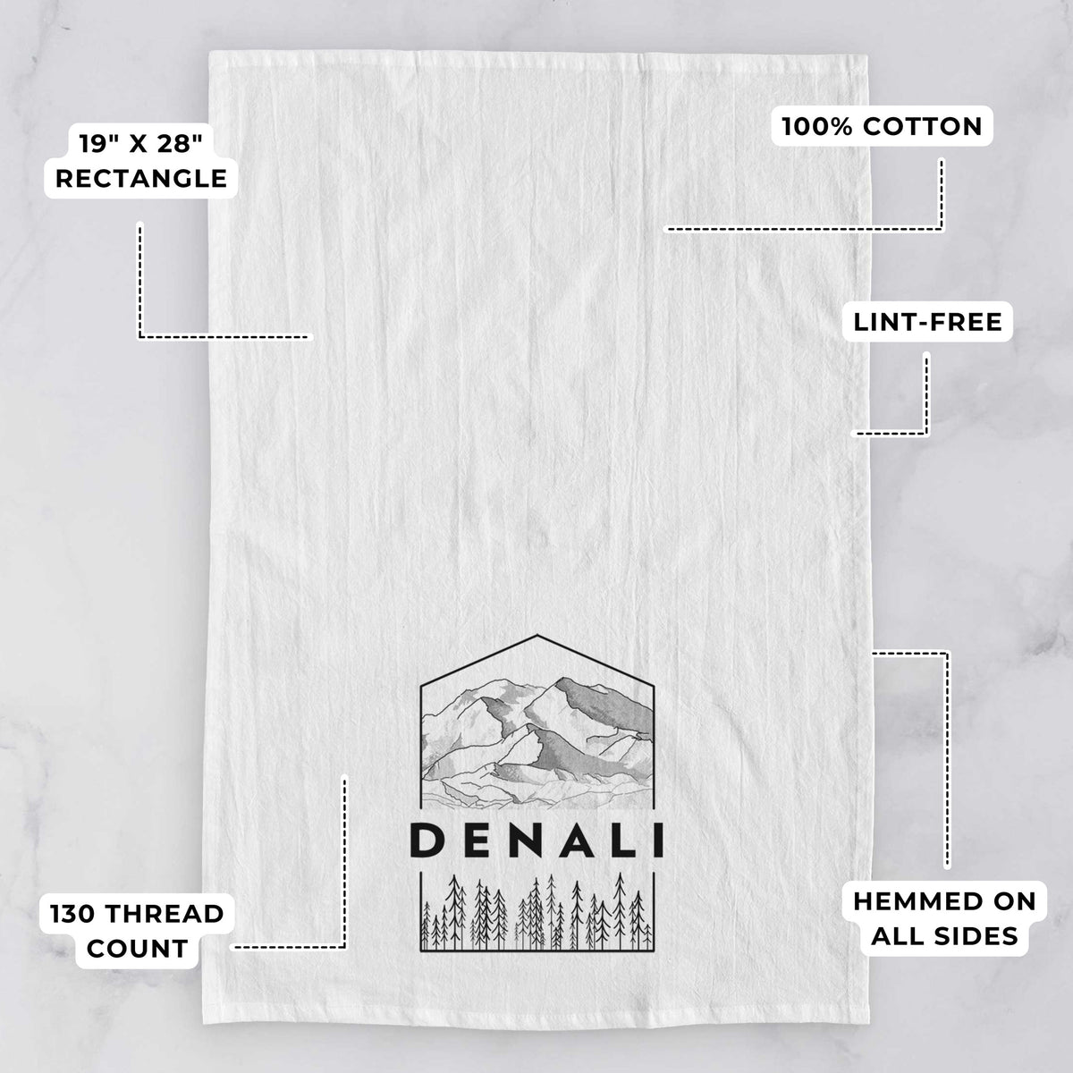 White tea towel printed with a black line art badge of the Denali mountain range above pine trees, with the word Denali, with feature labels: 19 by 28 inch rectangle, 100% cotton, lint-free, 130 thread count, hemmed on all sides.