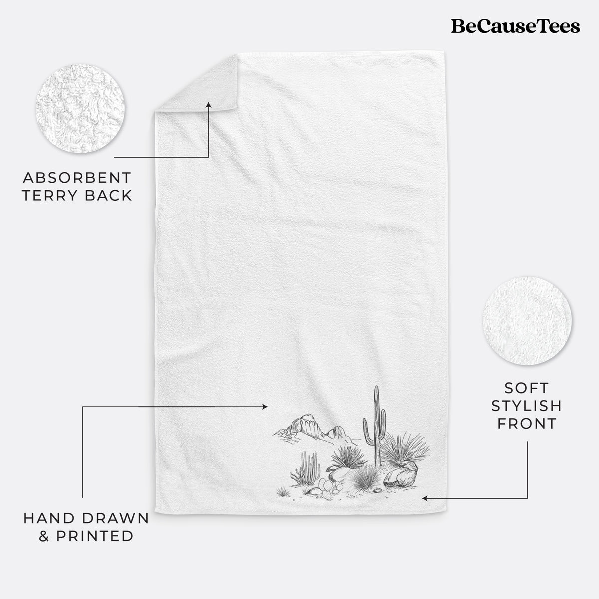 White hand towel printed with a black ink desert scene with a saguaro cactus, agave, rocks and distant mountains.