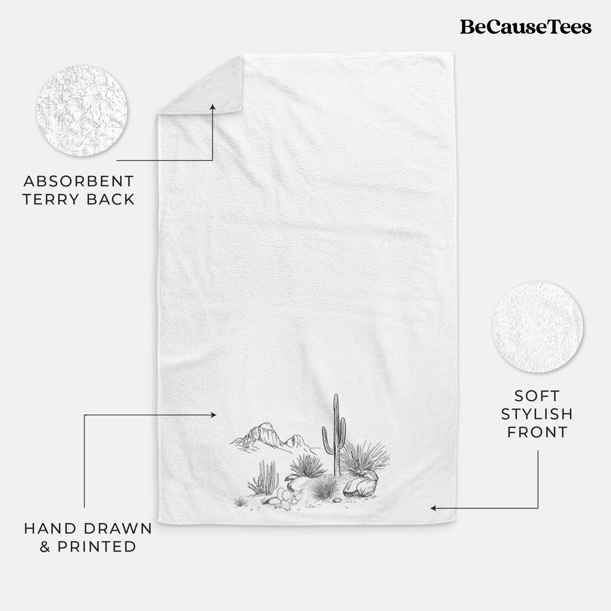 White hand towel printed with a black ink desert scene with a saguaro cactus, agave, rocks and distant mountains.