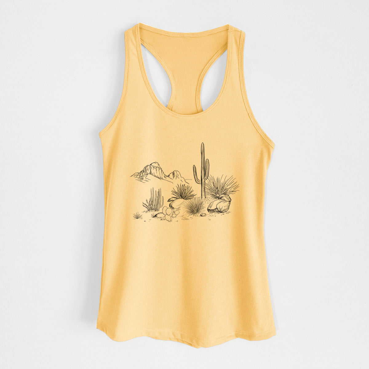 Banana cream women's racerback tank top laid flat, printed with a black ink desert scene with a saguaro cactus, agave, rocks and distant mountains.