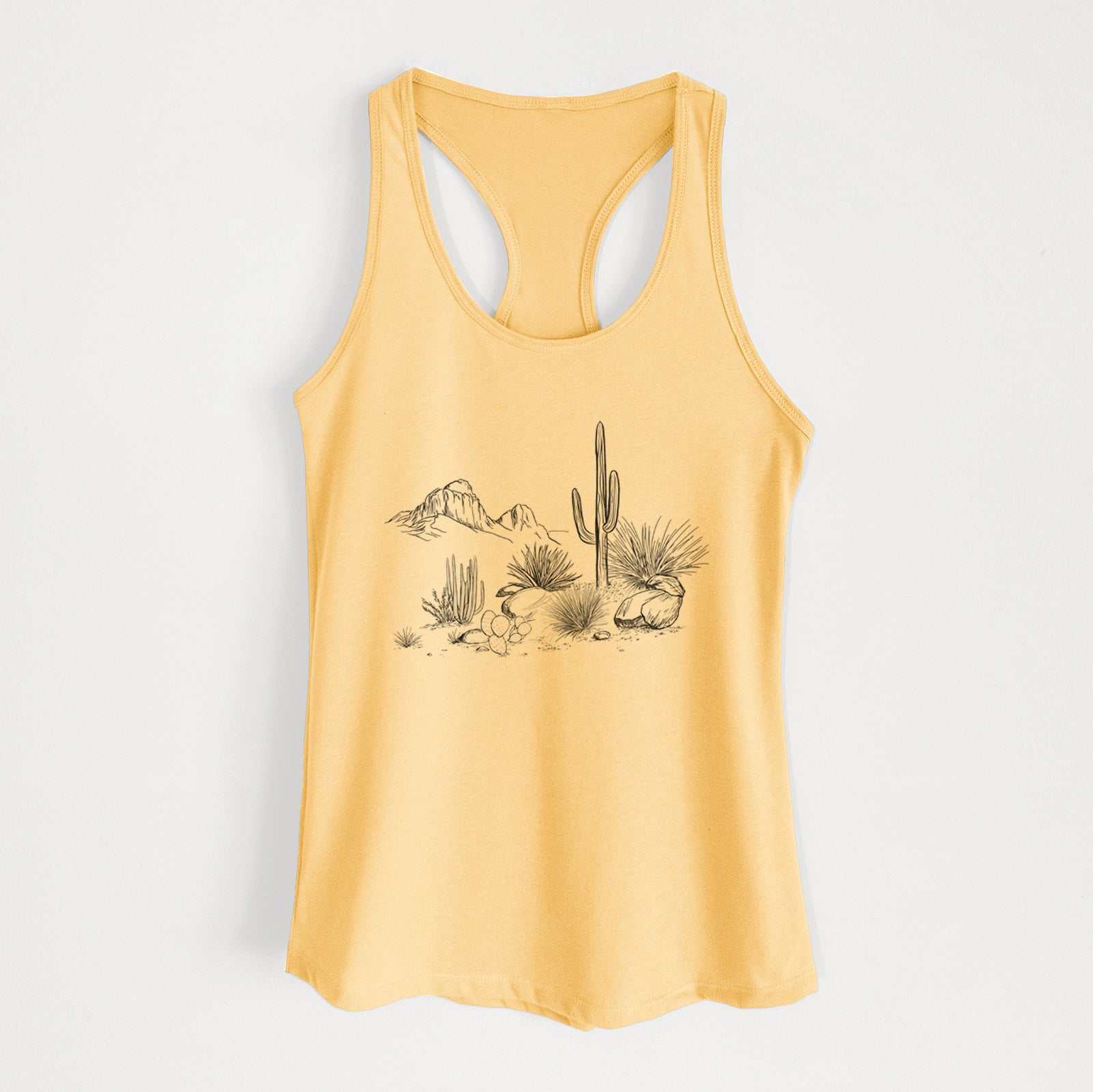 Banana cream women's racerback tank top laid flat, printed with a black ink desert scene with a saguaro cactus, agave, rocks and distant mountains.