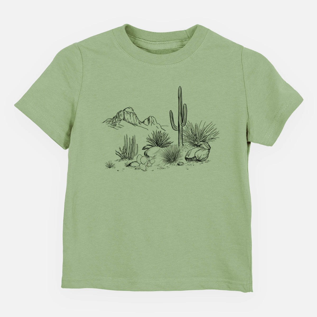 Sage green toddler t-shirt laid flat, printed with a black ink desert scene with a saguaro cactus, agave, rocks and distant mountains.