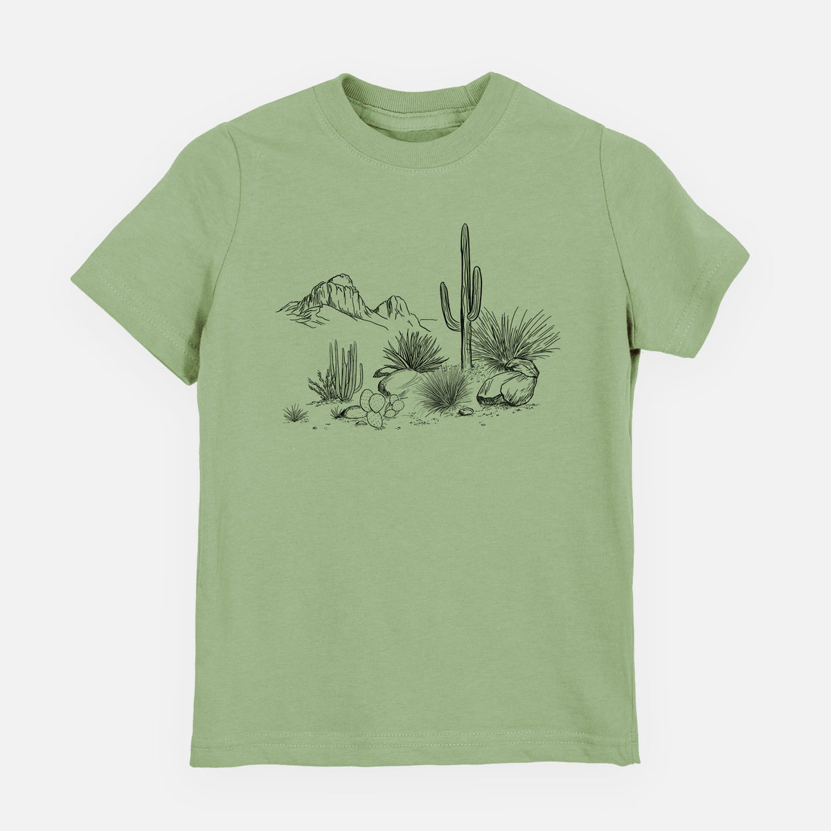 Sage green youth t-shirt laid flat, printed with a black ink desert scene with a saguaro cactus, agave, rocks and distant mountains.