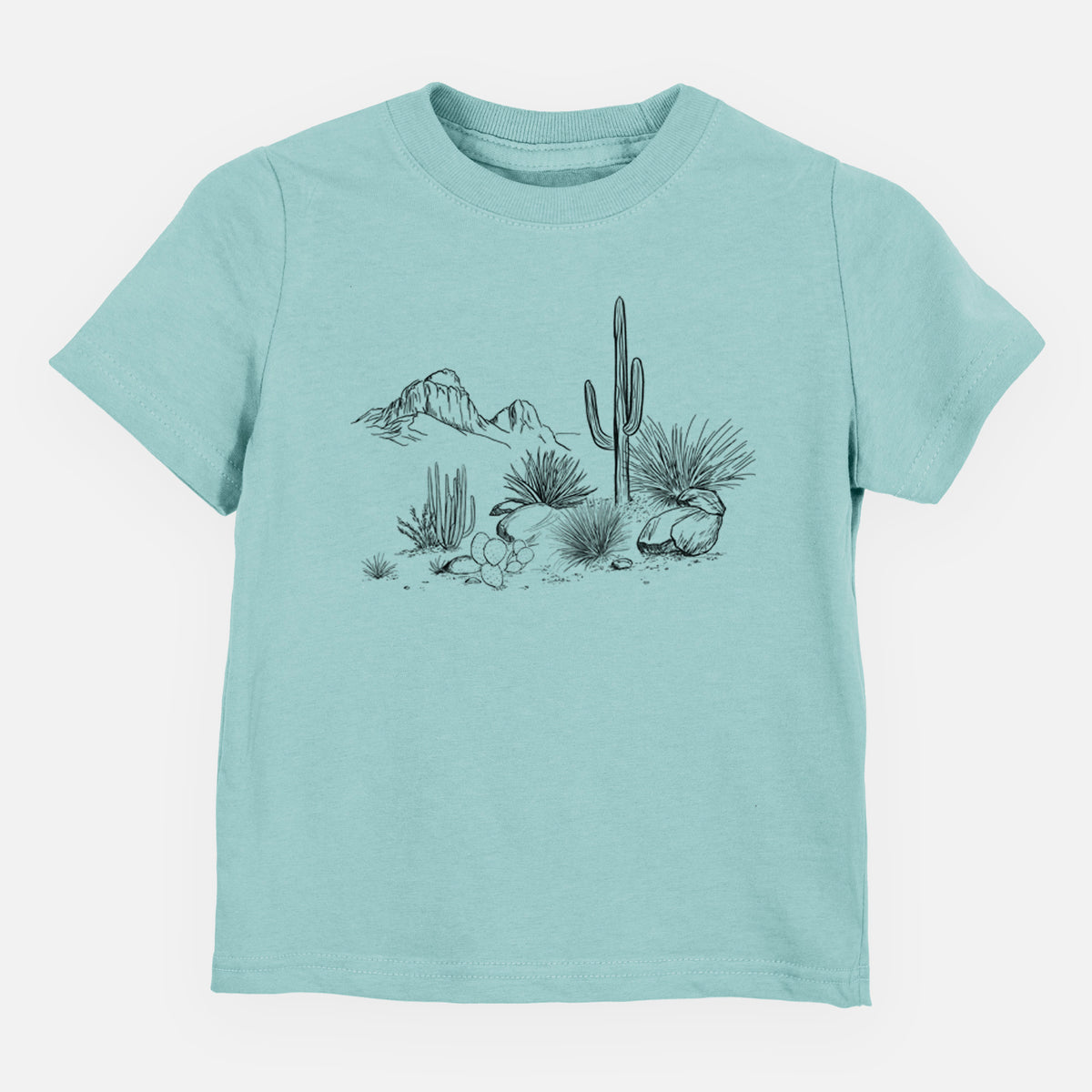 Saltwater toddler t-shirt laid flat, printed with a black ink desert scene with a saguaro cactus, agave, rocks and distant mountains.