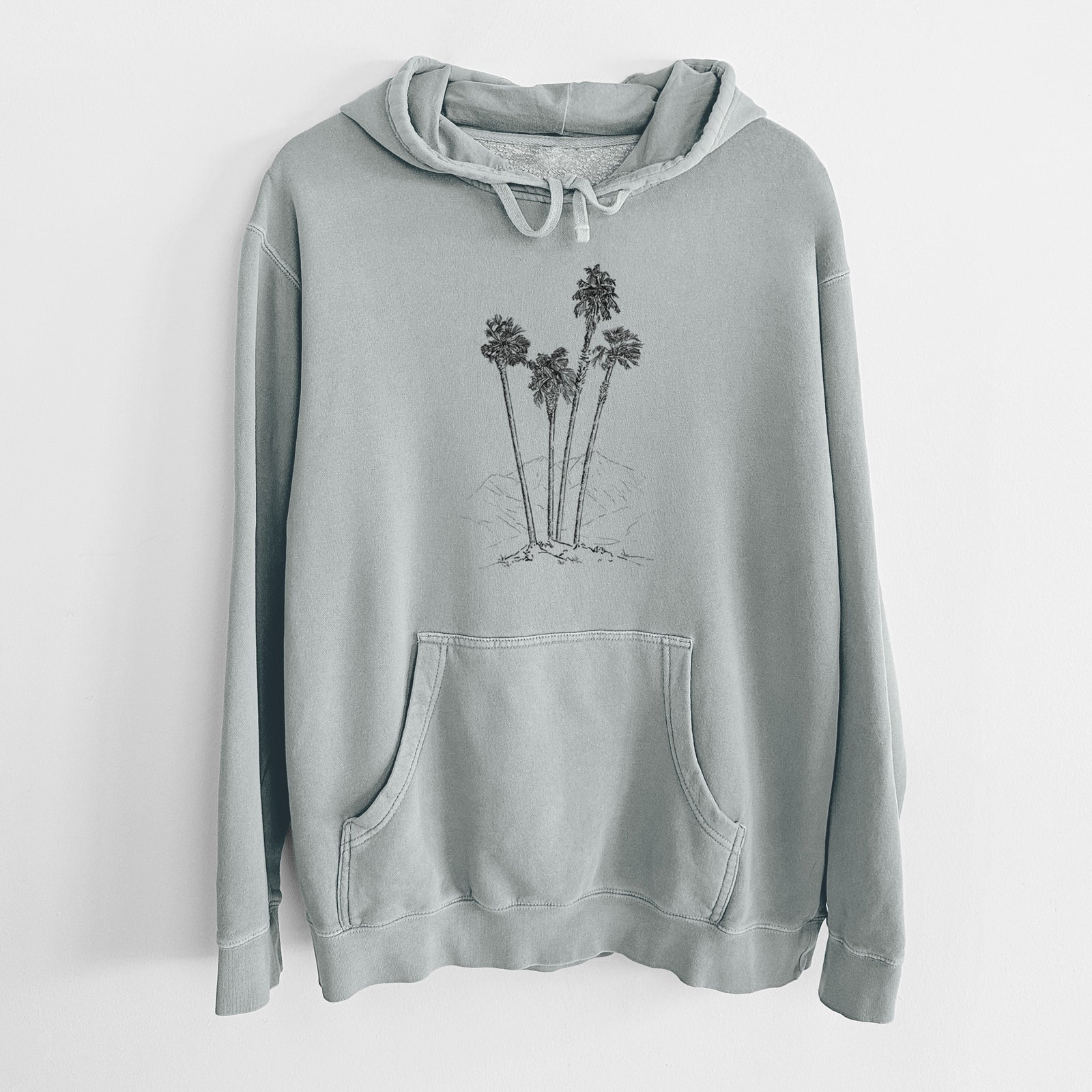 Sage green pigment dyed hoodie laid flat, printed with a black ink illustration of a cluster of tall desert palm trees.