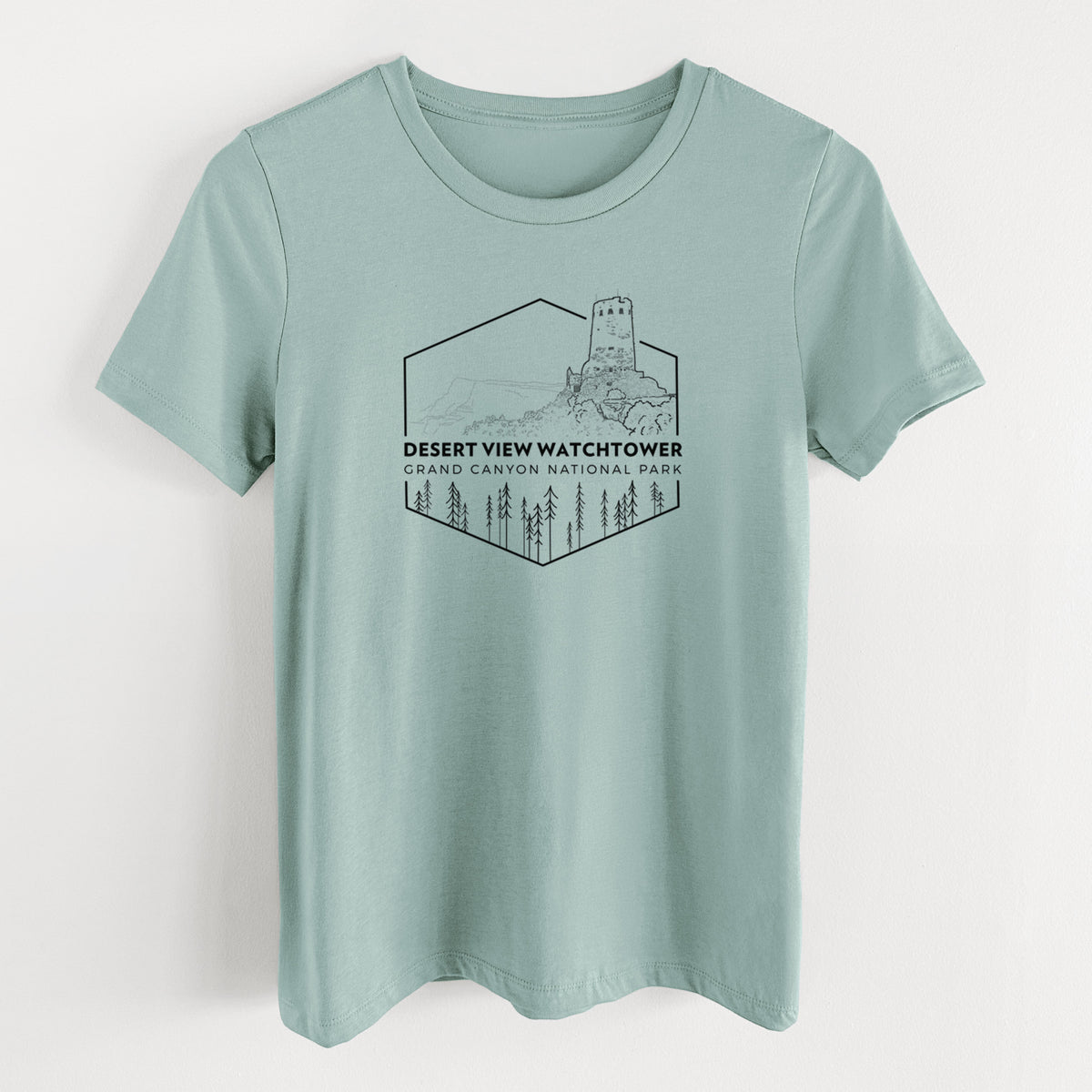 Dusty blue women's relaxed fit cotton t-shirt laid flat, printed with a black line art badge of the Desert View Watchtower above pine trees, with the words Desert View Watchtower, Grand Canyon National Park.