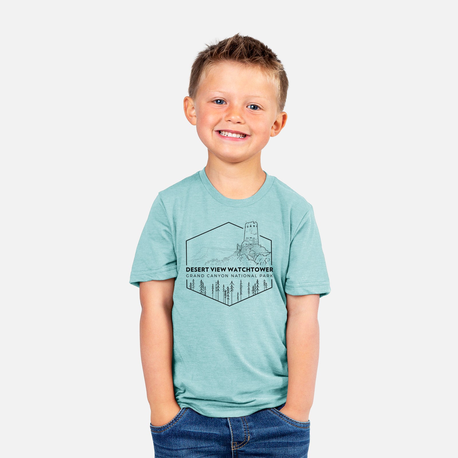 Two youth t-shirts in different colors on hangers, printed with a black line art badge of the Desert View Watchtower above pine trees, with the words Desert View Watchtower, Grand Canyon National Park.
