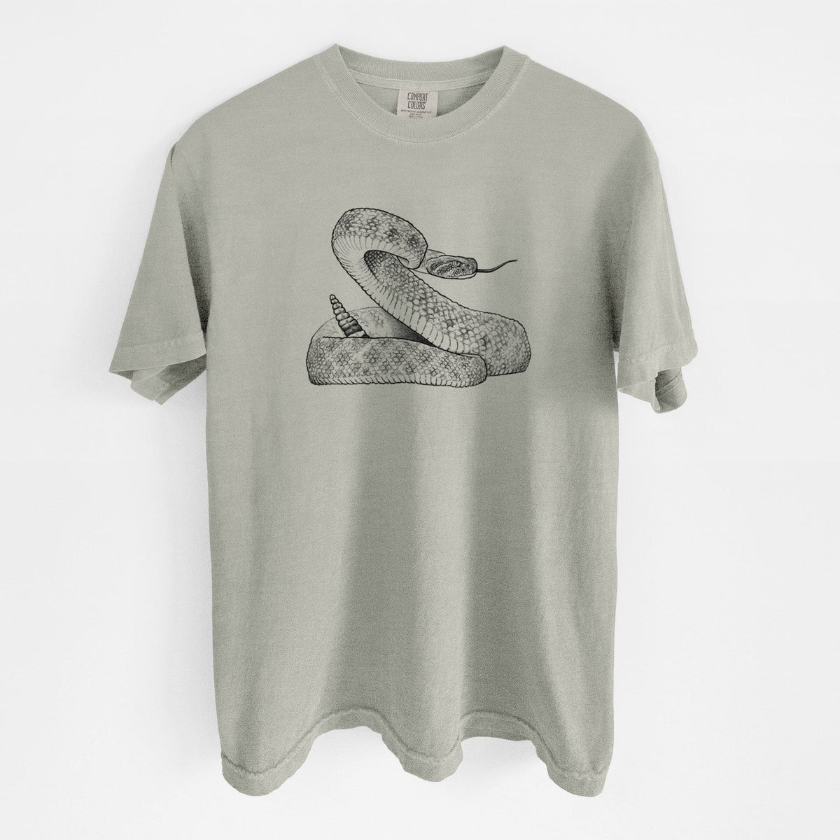Sandstone beige Comfort Colors t-shirt laid flat, printed with a detailed black ink illustration of a coiled diamondback rattlesnake.