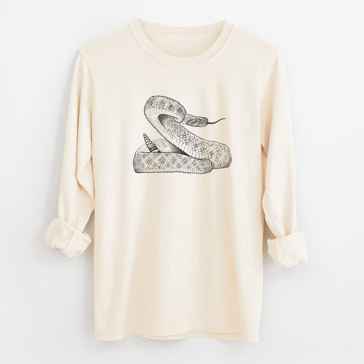 Ivory Comfort Colors long sleeve shirt laid flat with the cuffs rolled, printed with a detailed black ink illustration of a coiled diamondback rattlesnake.