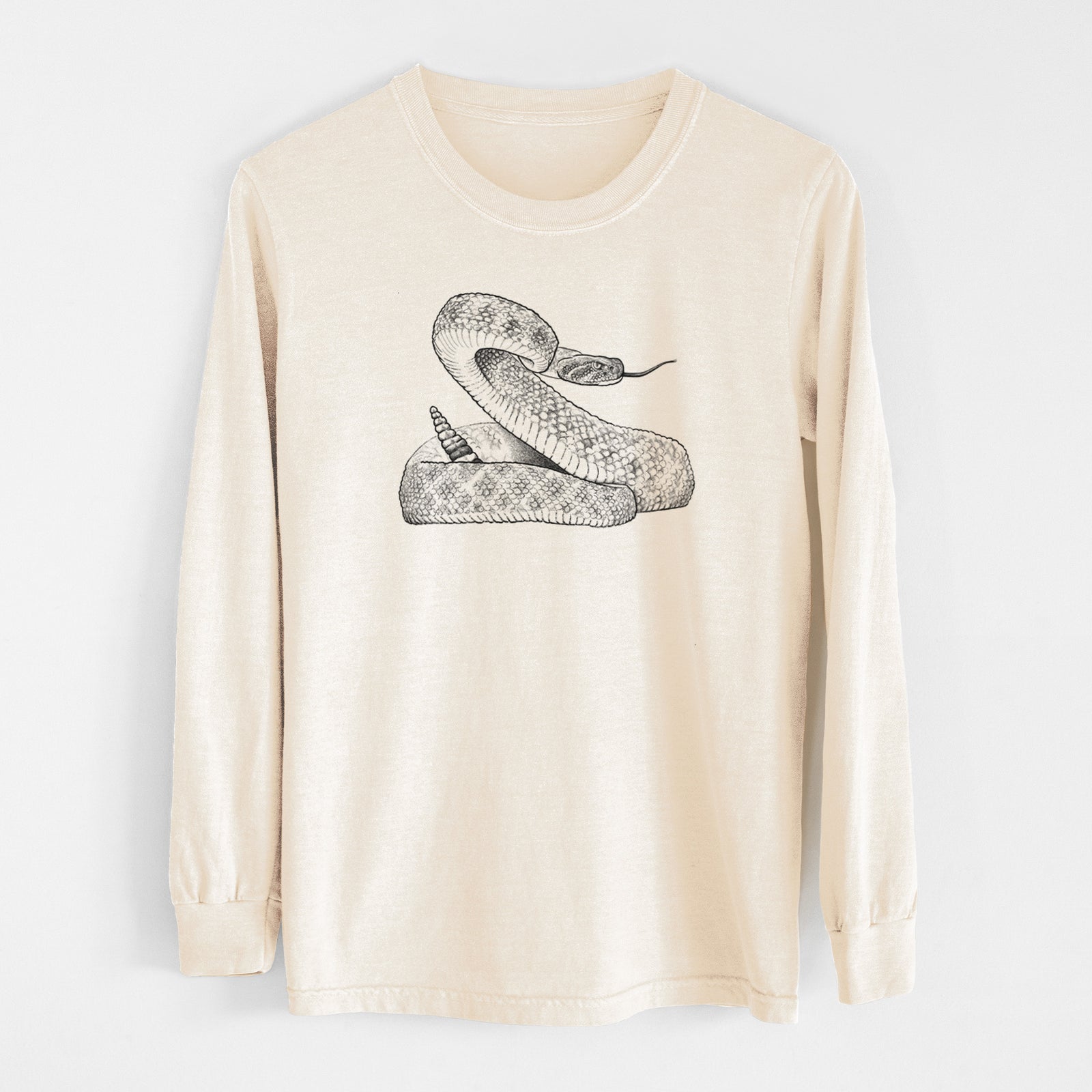 Ivory Comfort Colors long sleeve shirt laid flat, printed with a detailed black ink illustration of a coiled diamondback rattlesnake.