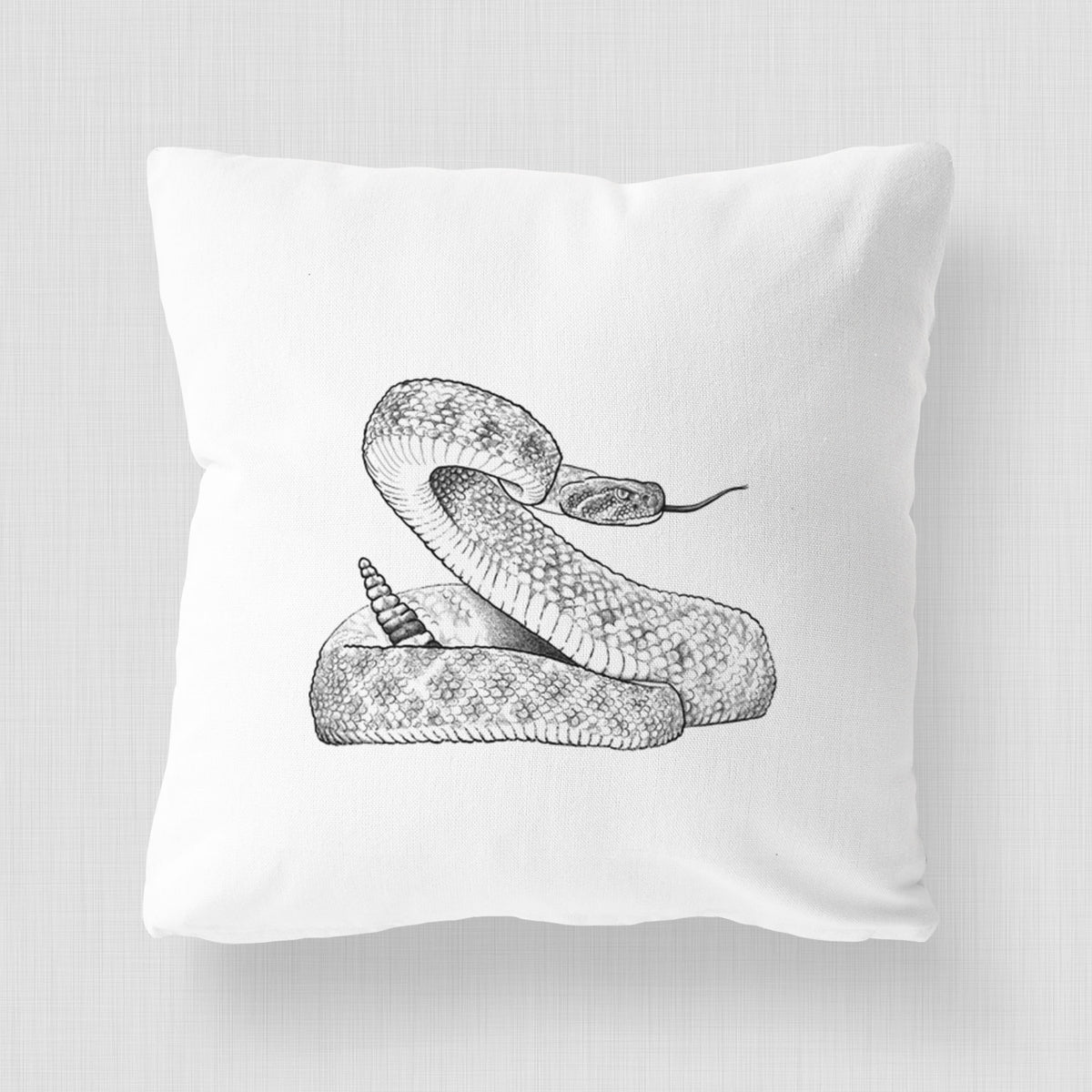 White pillow cover printed with a detailed black ink illustration of a coiled diamondback rattlesnake.