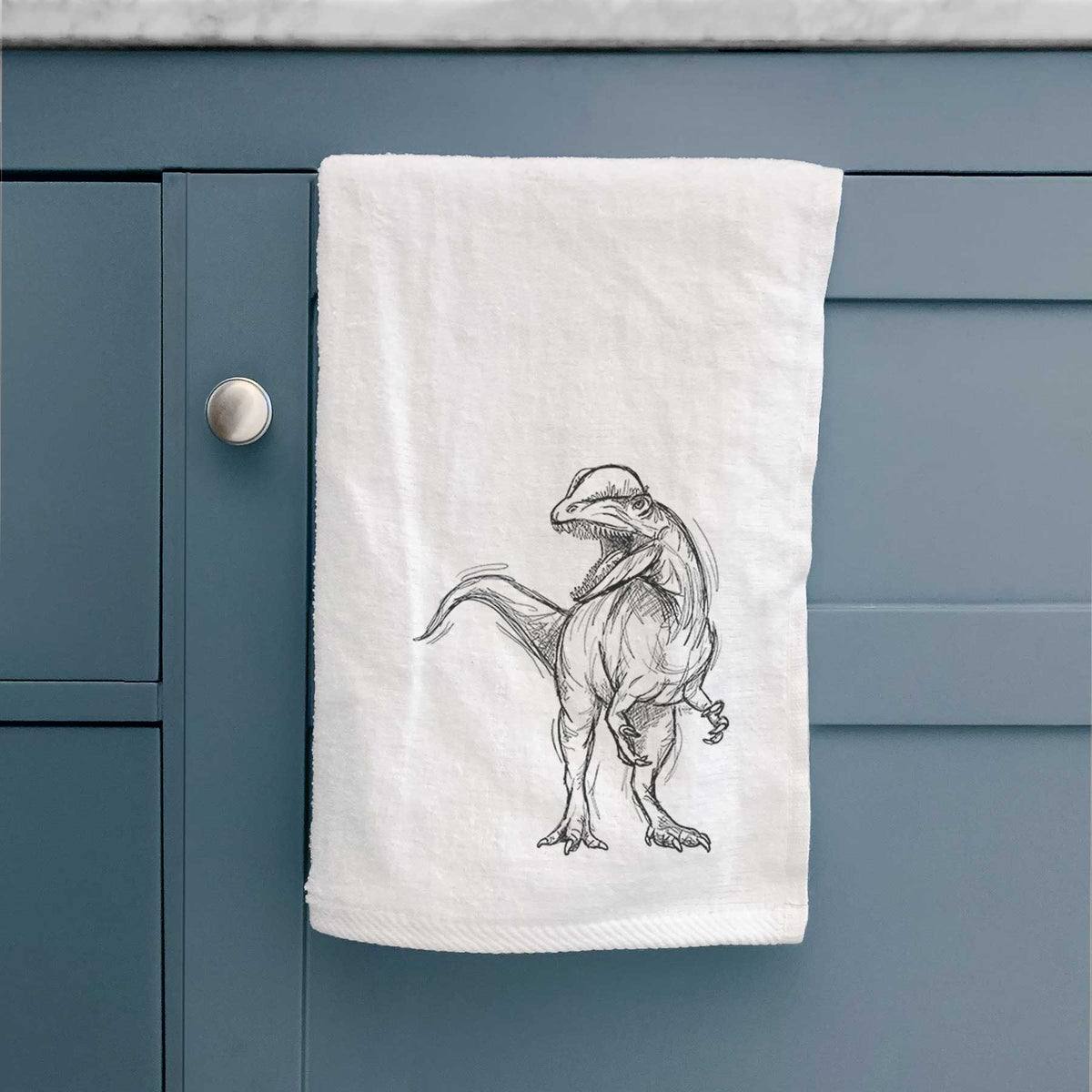 White hand towel printed with a black ink illustration of a Dilophosaurus with its neck frill, walking.